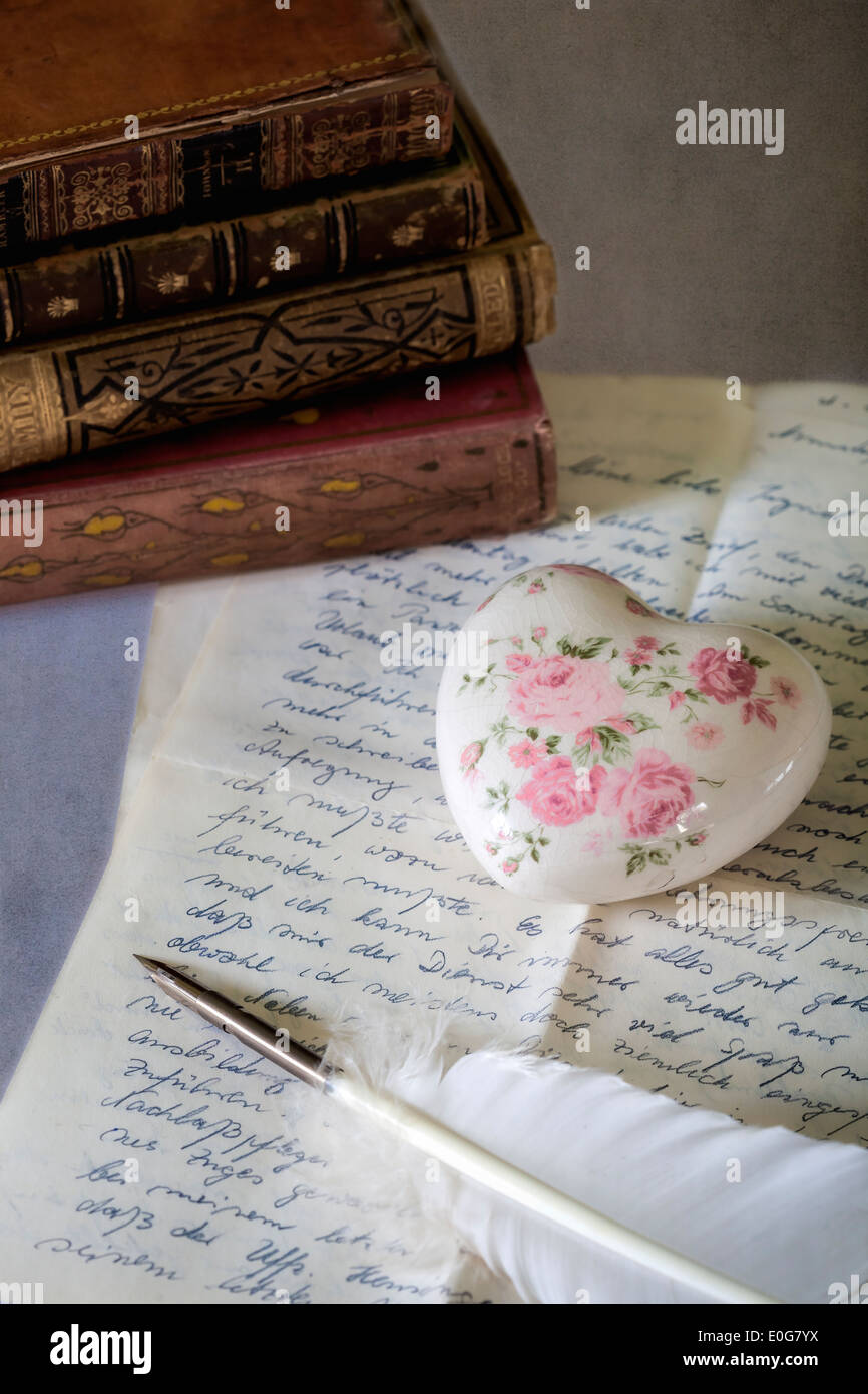 eine Feder auf einen alten Brief mit Büchern Stockfoto