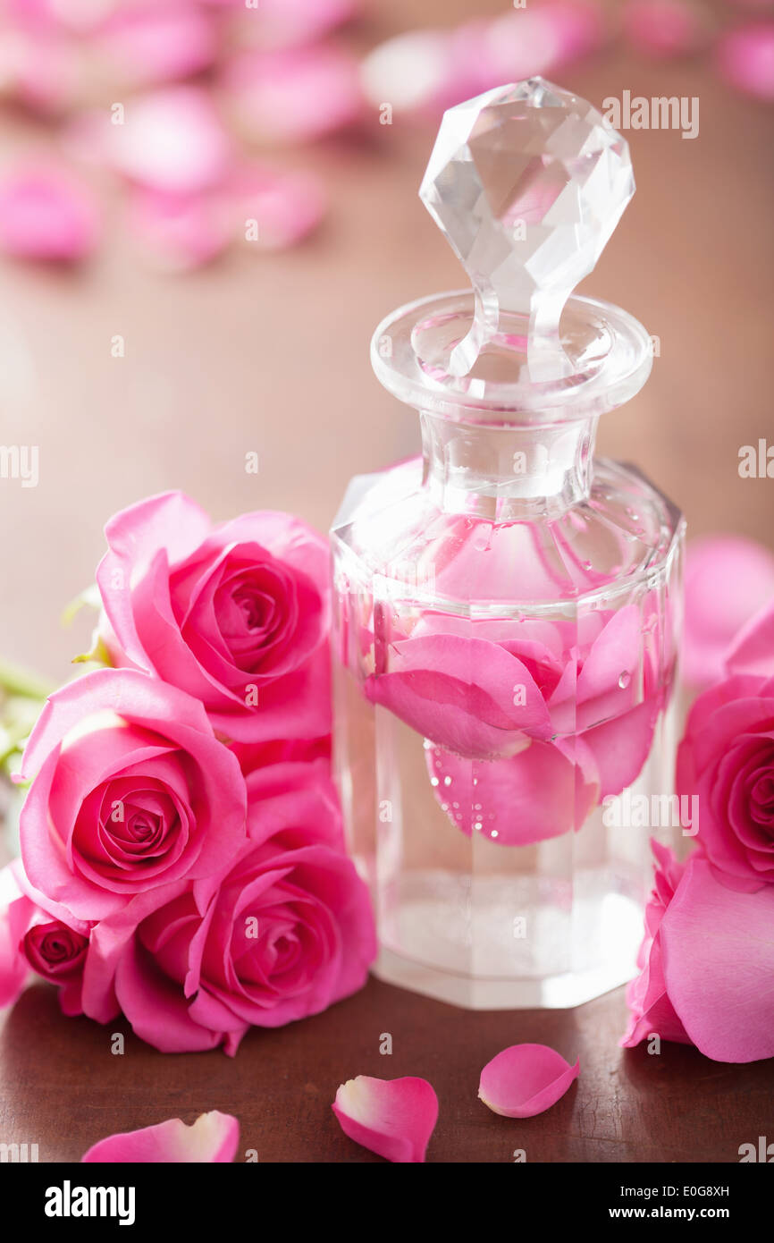 Parfüm-Flasche und rosa Rosenblüten. Spa Aromatherapie Stockfoto