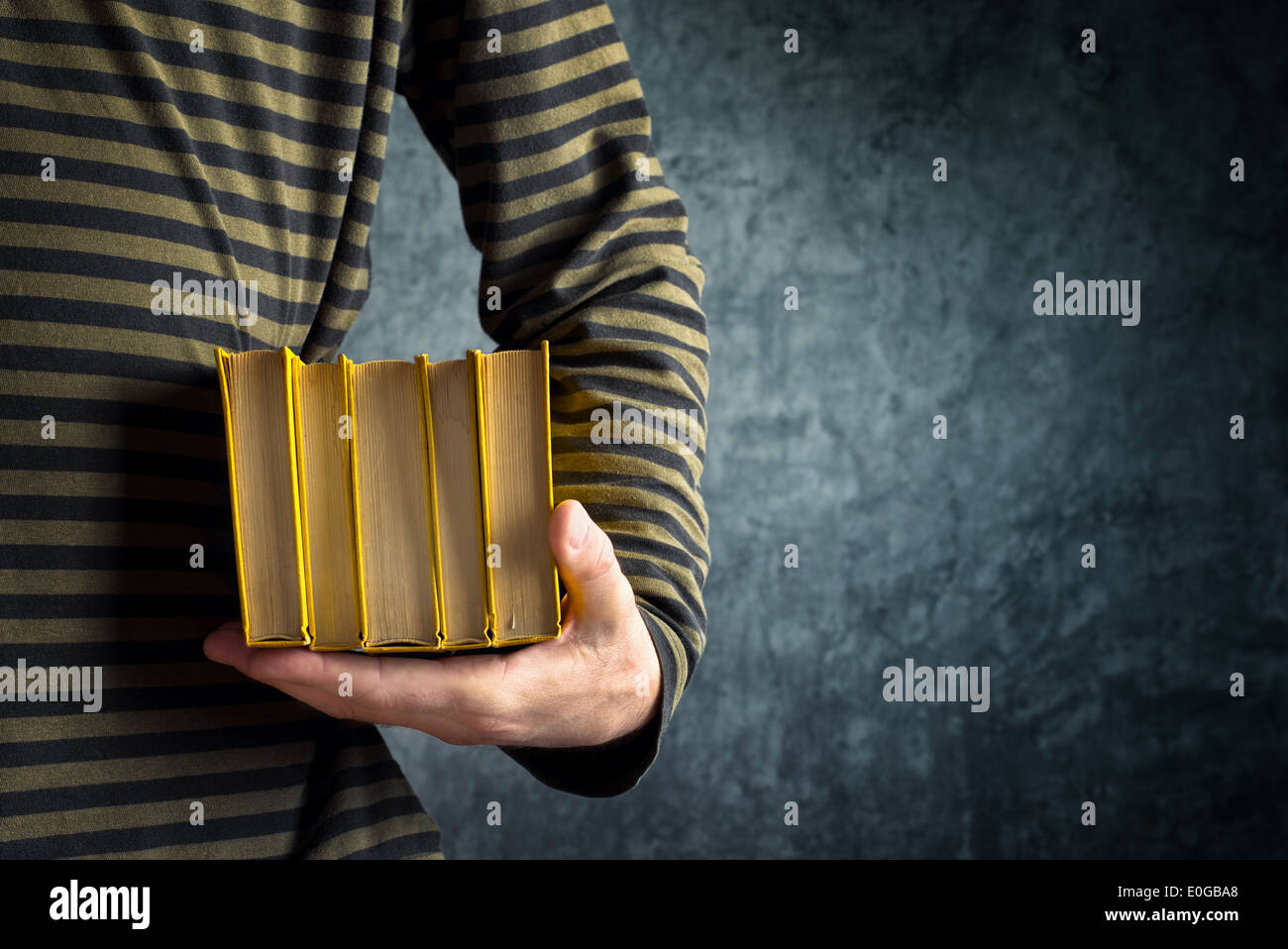 Legerer Mann Betrieb Stapel Alter gelb Hardcover Bücher Stockfoto
