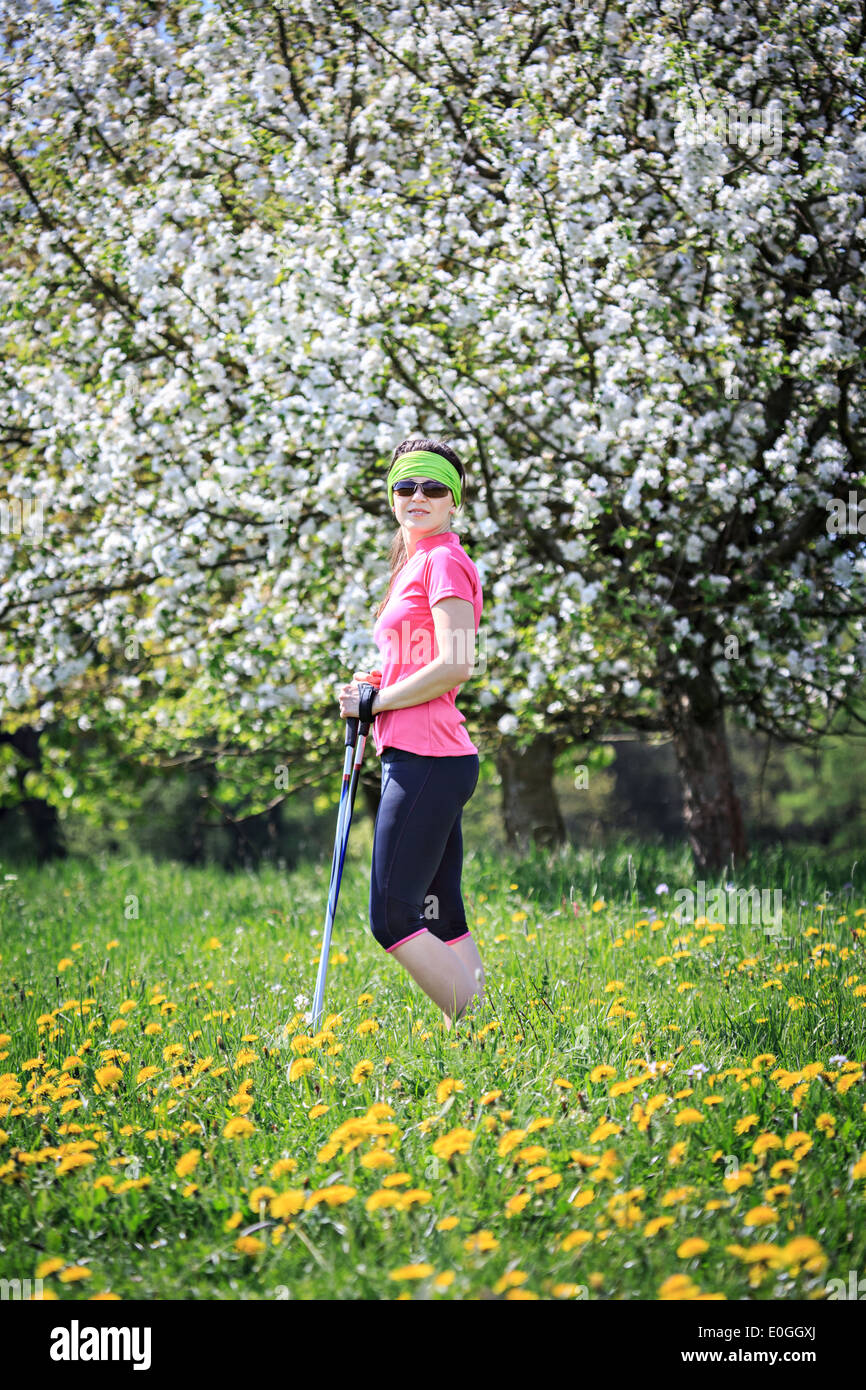 eine Frau nordic walking durch die Felder im Frühling Stockfoto