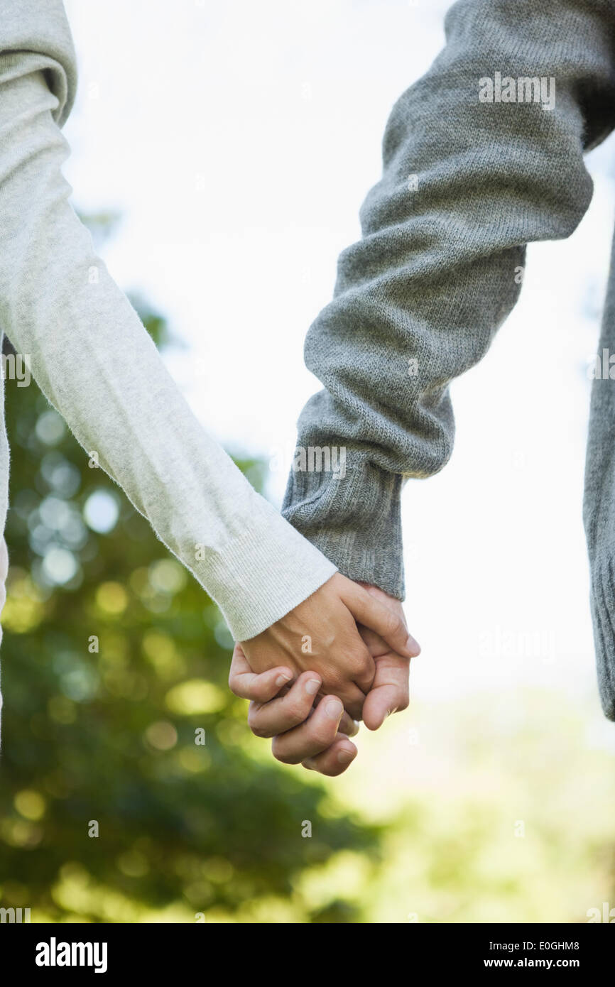 Süßes Paar halten die Hände im park Stockfoto
