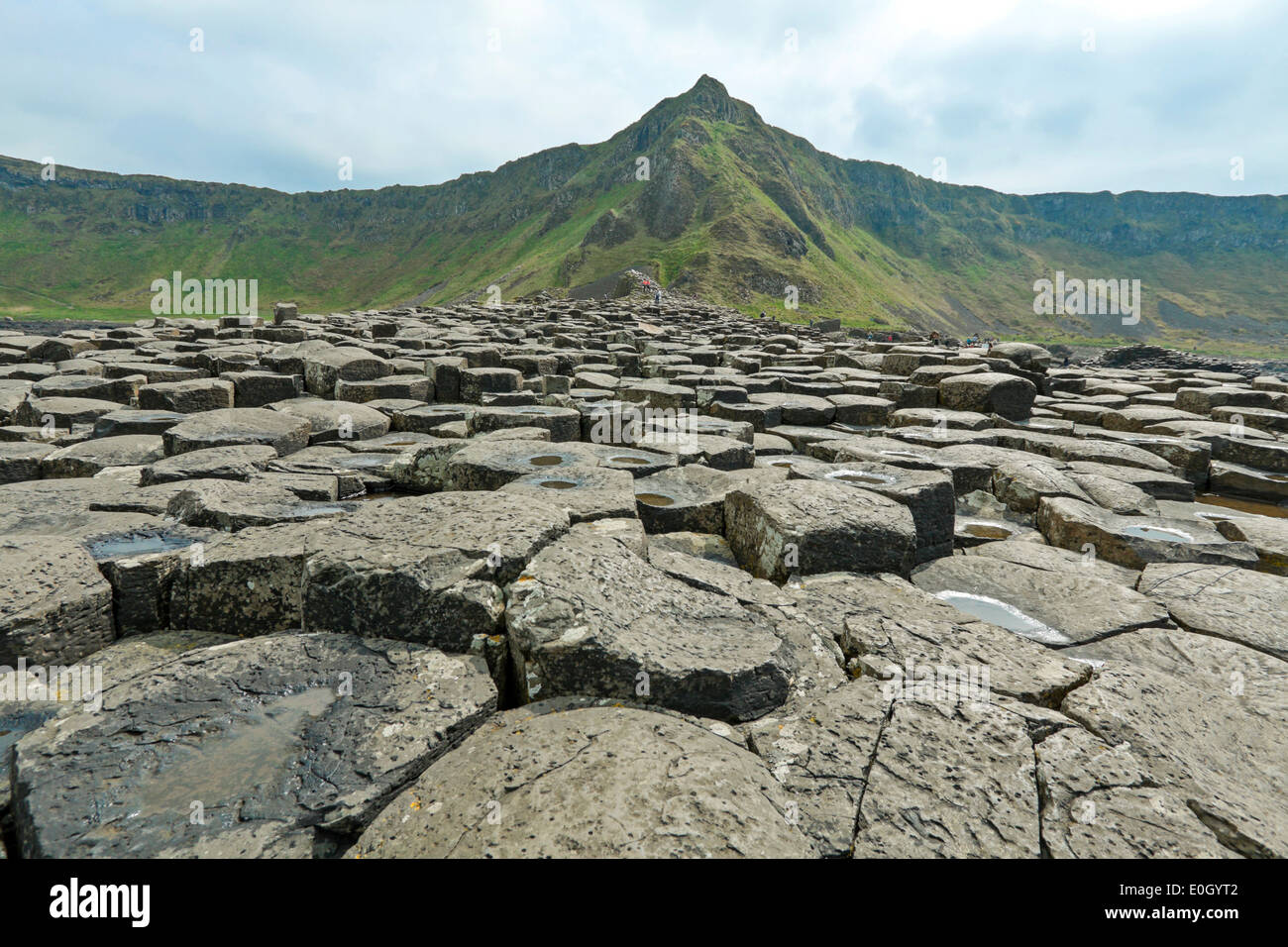 Touristen erkunden den Giant's Causeway, County Antrim, Nordirland, Vereinigtes Königreich, einem berühmten UNESCO-Weltkulturerbe. Stockfoto