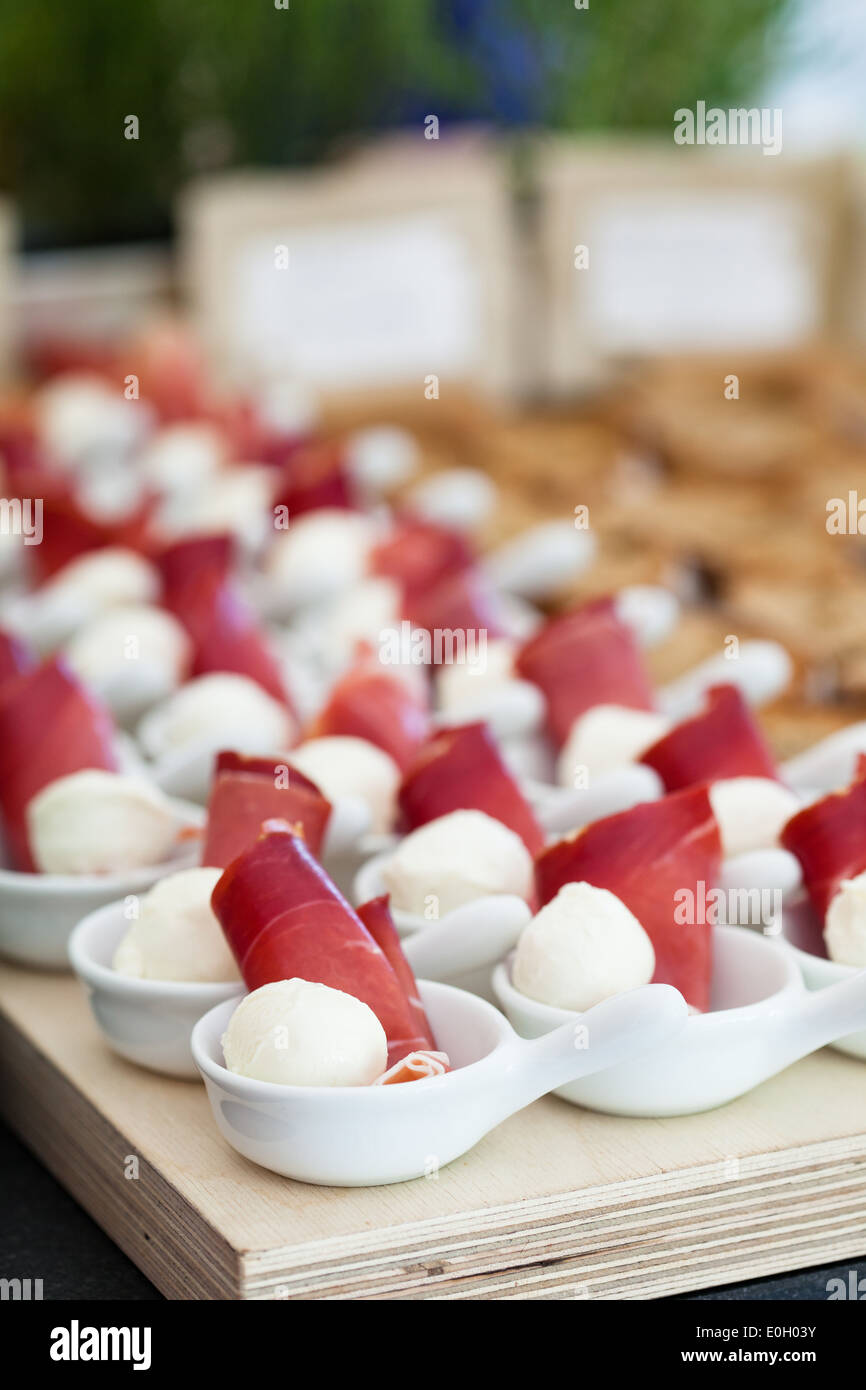 Nahaufnahme von Schinken und Kugel geformt Mozzarella Käse Häppchen in Reihen von kleinen weißen Schüsseln Stockfoto