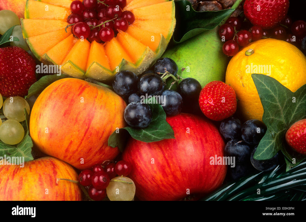 Fruchtvielfalt - Trauben, Melone, rote Johannisbeeren, Erdbeeren, Kiwi, Birne Stockfoto