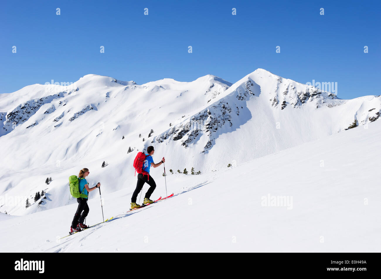 Zwei Backcountry Skifahrer zum Brechhorn, Grosser Rettenstein im Hintergrund, Kitzbüheler Alpen, Tirol, Österreich Stockfoto