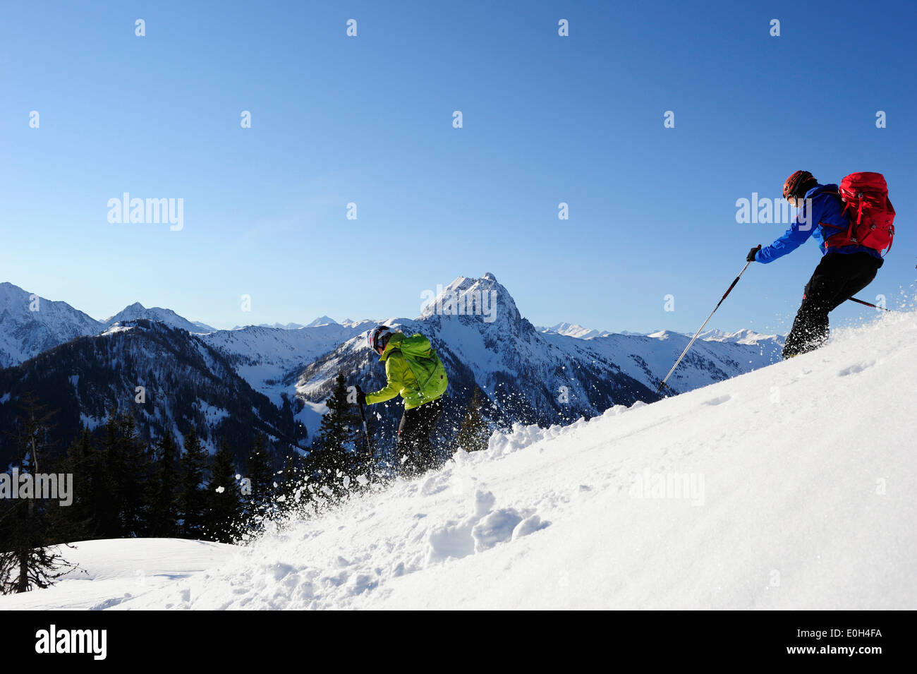 Zwei Backcountry Skifahrer Downhill Ski von Mount Brechhorn, Grosser Rettenstein im Hintergrund, Kitzbüheler Alpen, Tirol, Österreich Stockfoto