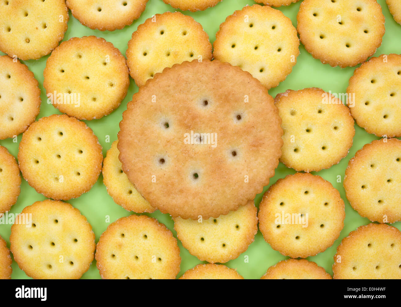 Eine Gruppe von kleinen Imbiss Cracker auf einer grünen Platte mit einem größeren Cracker an der Spitze. Stockfoto