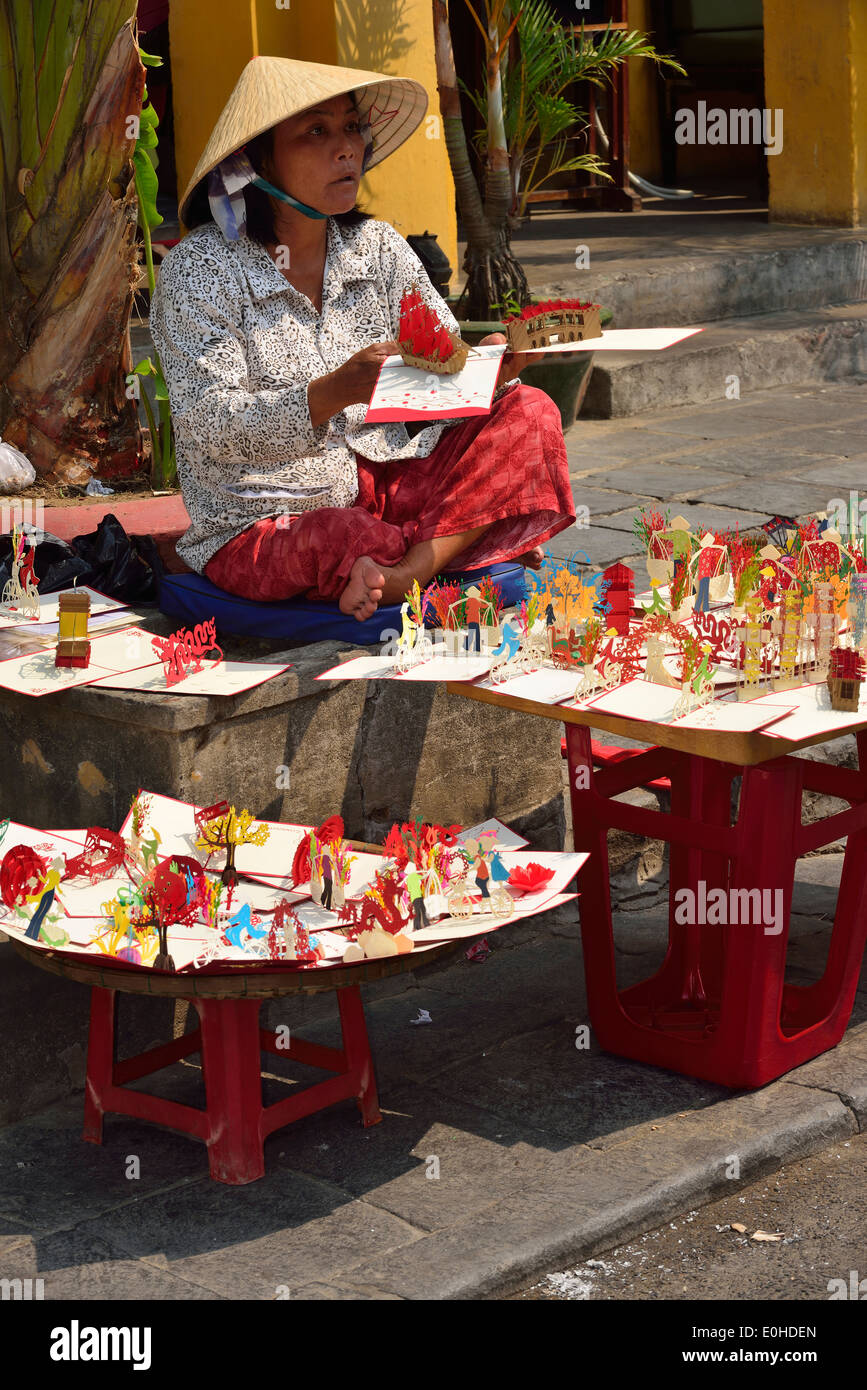 Vietnamesischer Straßenverkäufer, der in der alten Stadt Hoi an, Vietnam, Origami-Karten an Touristen verkauft Stockfoto