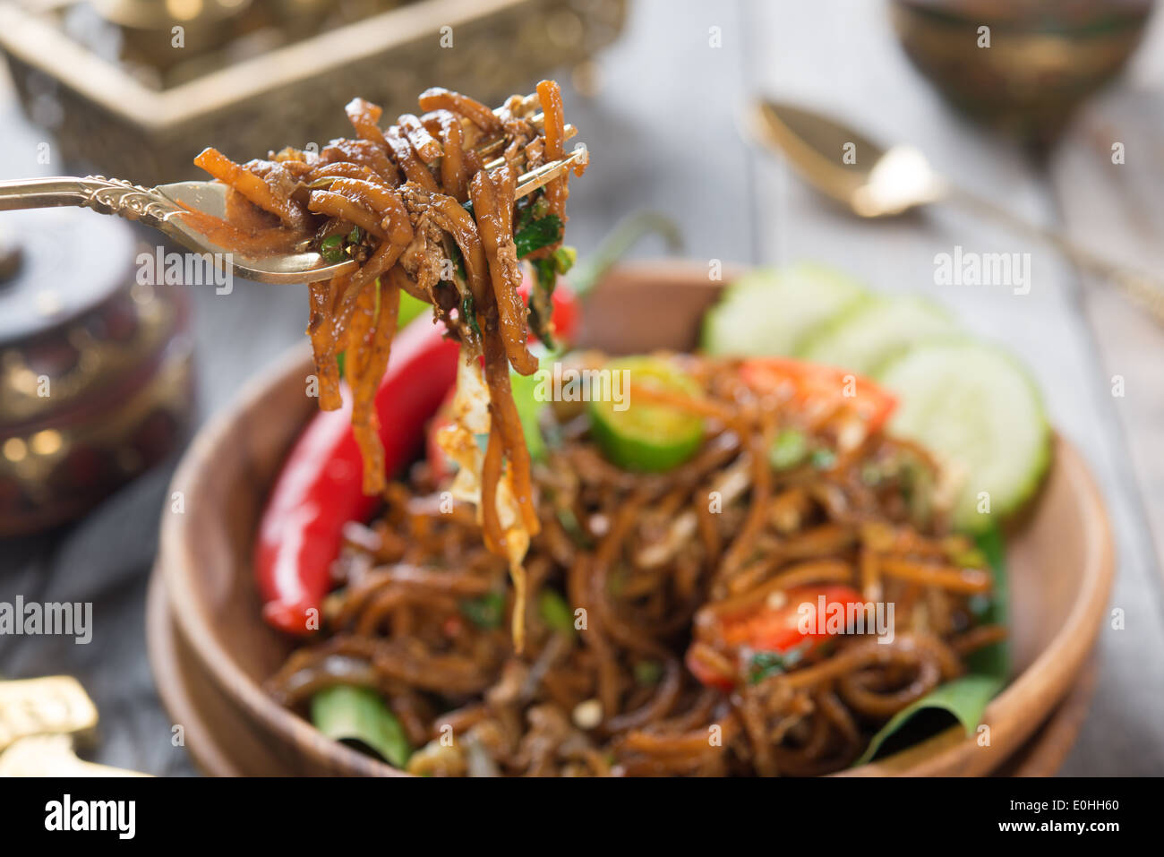 Leckere asiatische würzig gebratene Nudeln, am Esstisch servierfertig. Stockfoto