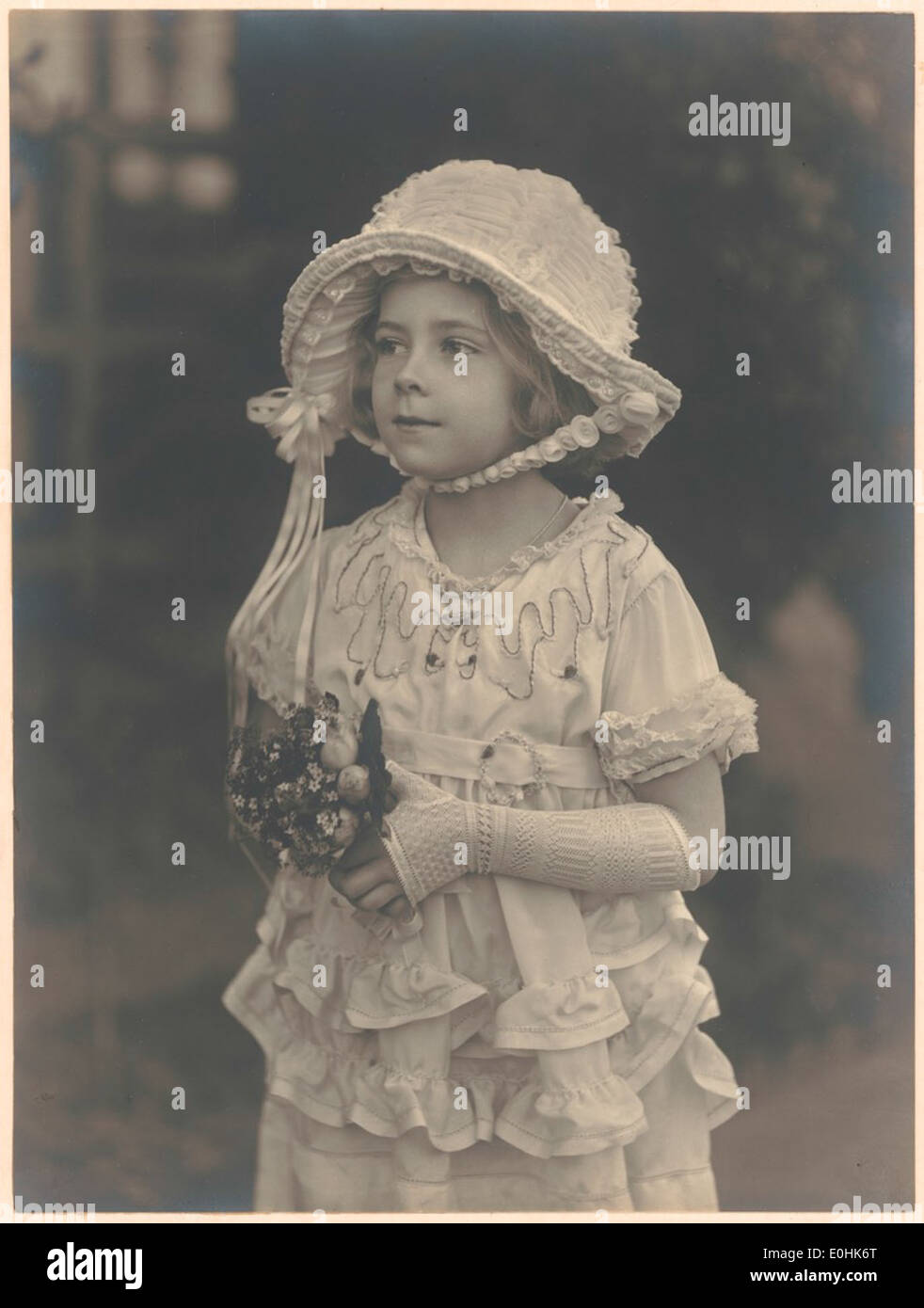 Porträt von Helen Hughes als Kind in Motorhaube und lange Handschuhe mit einem kleinen Blumenstrauß Stockfoto