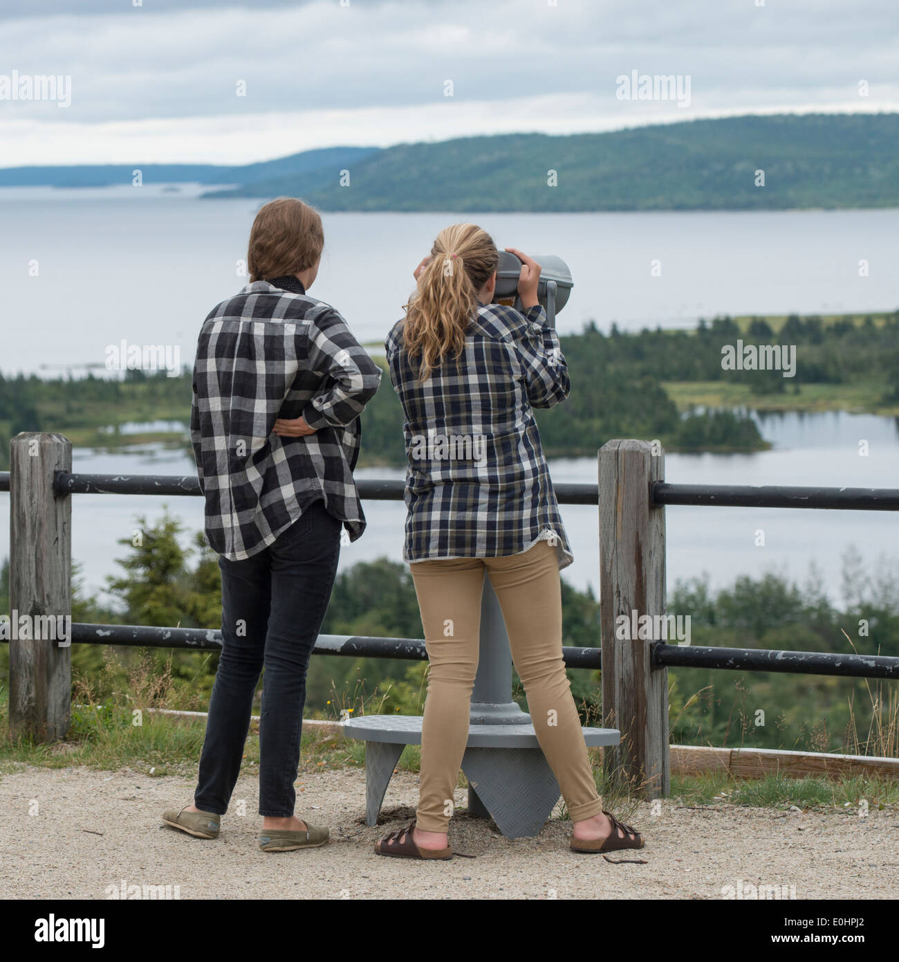 Mädchen auf der Suche im Blick auf die Bucht durch ein Münz-Fernglas, Joey es Lookout, Gambo, Neufundland und Labrador, Kanada Stockfoto