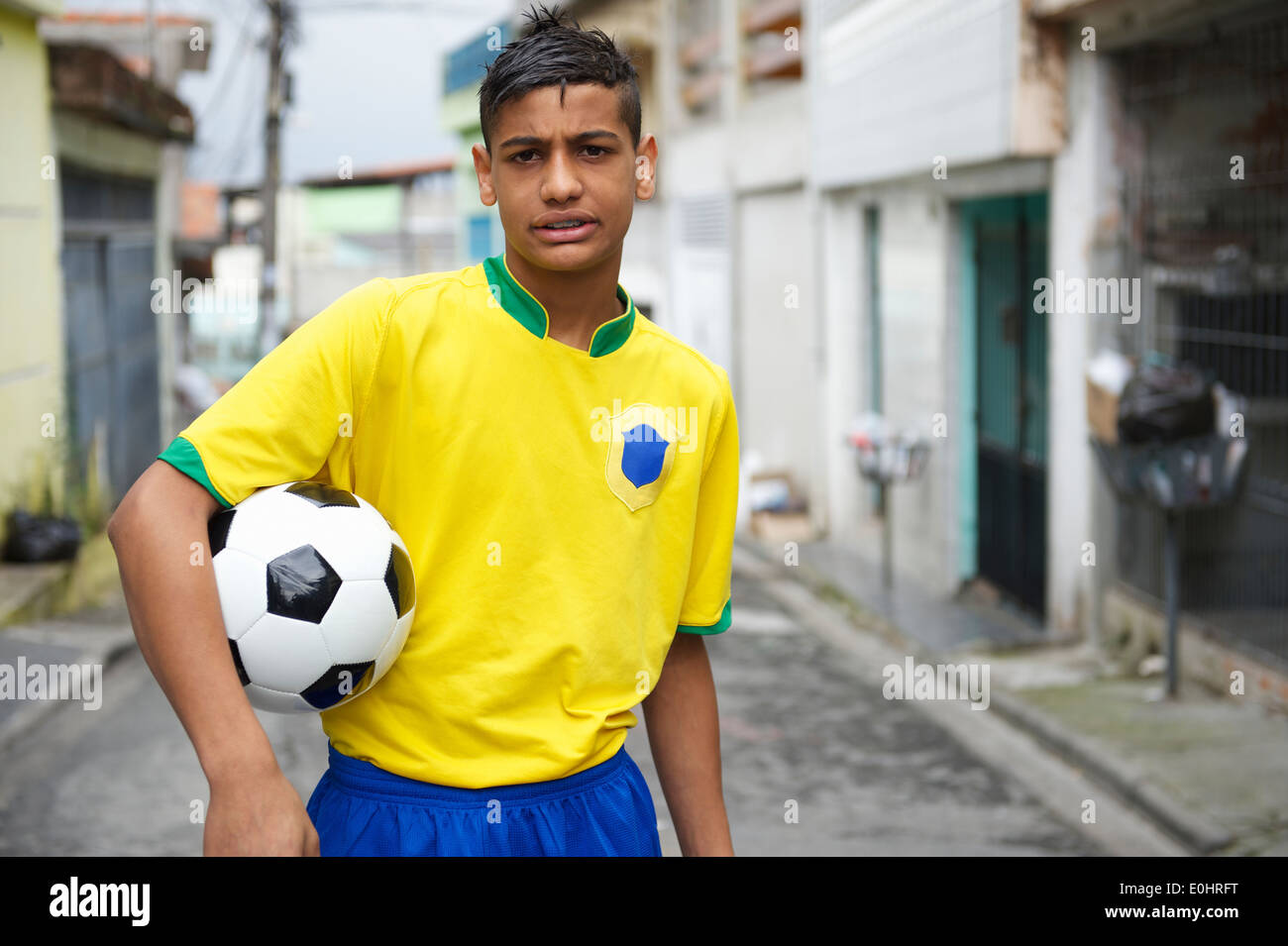 Porträt der jungen brasilianischen Fußballspieler, Fußball auf Nachbarschaft Straße Stockfoto