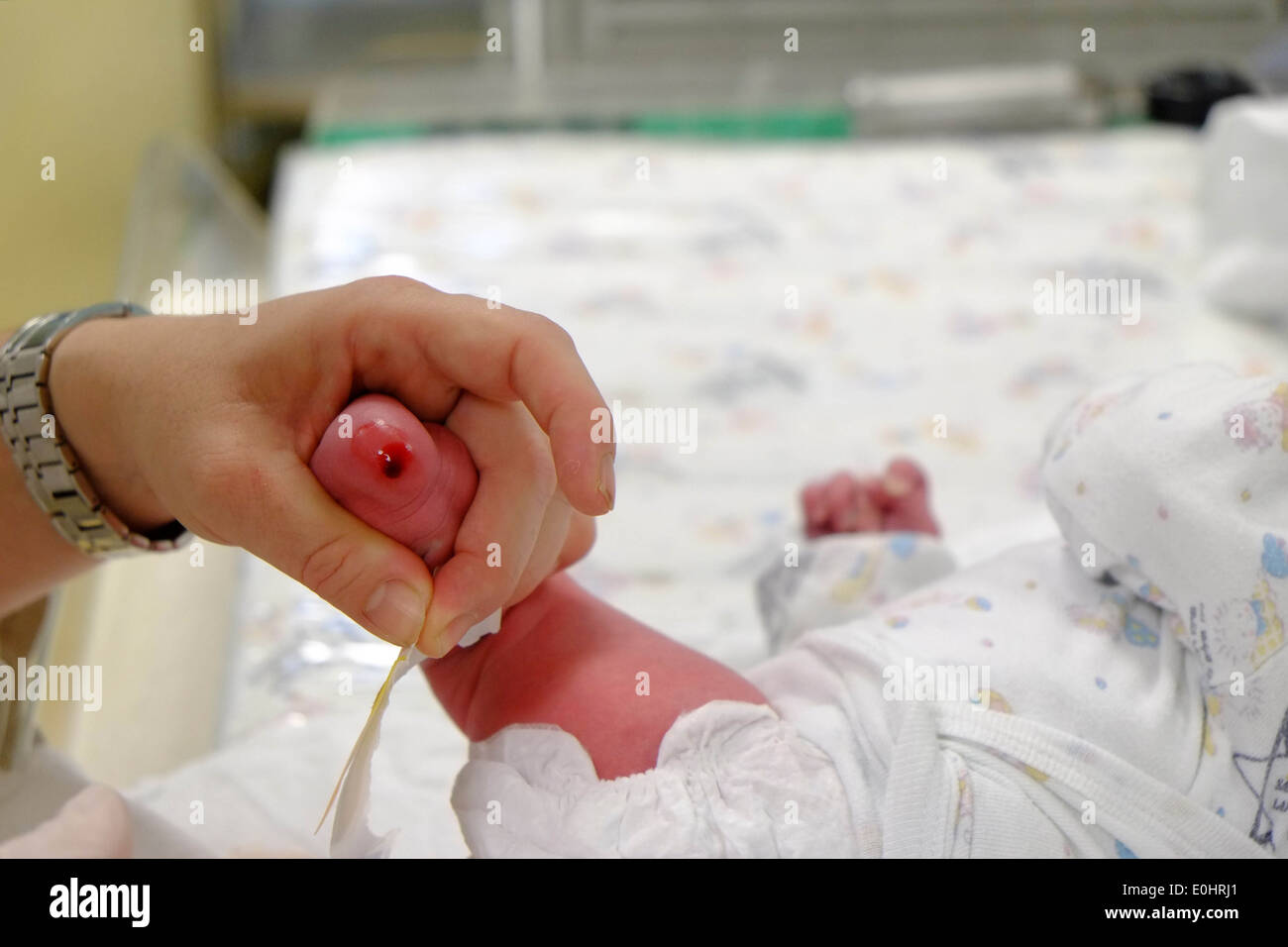 Arzt führt eine Blutuntersuchung auf ein neugeborenes Kind in einer Entbindungsstation Stockfoto