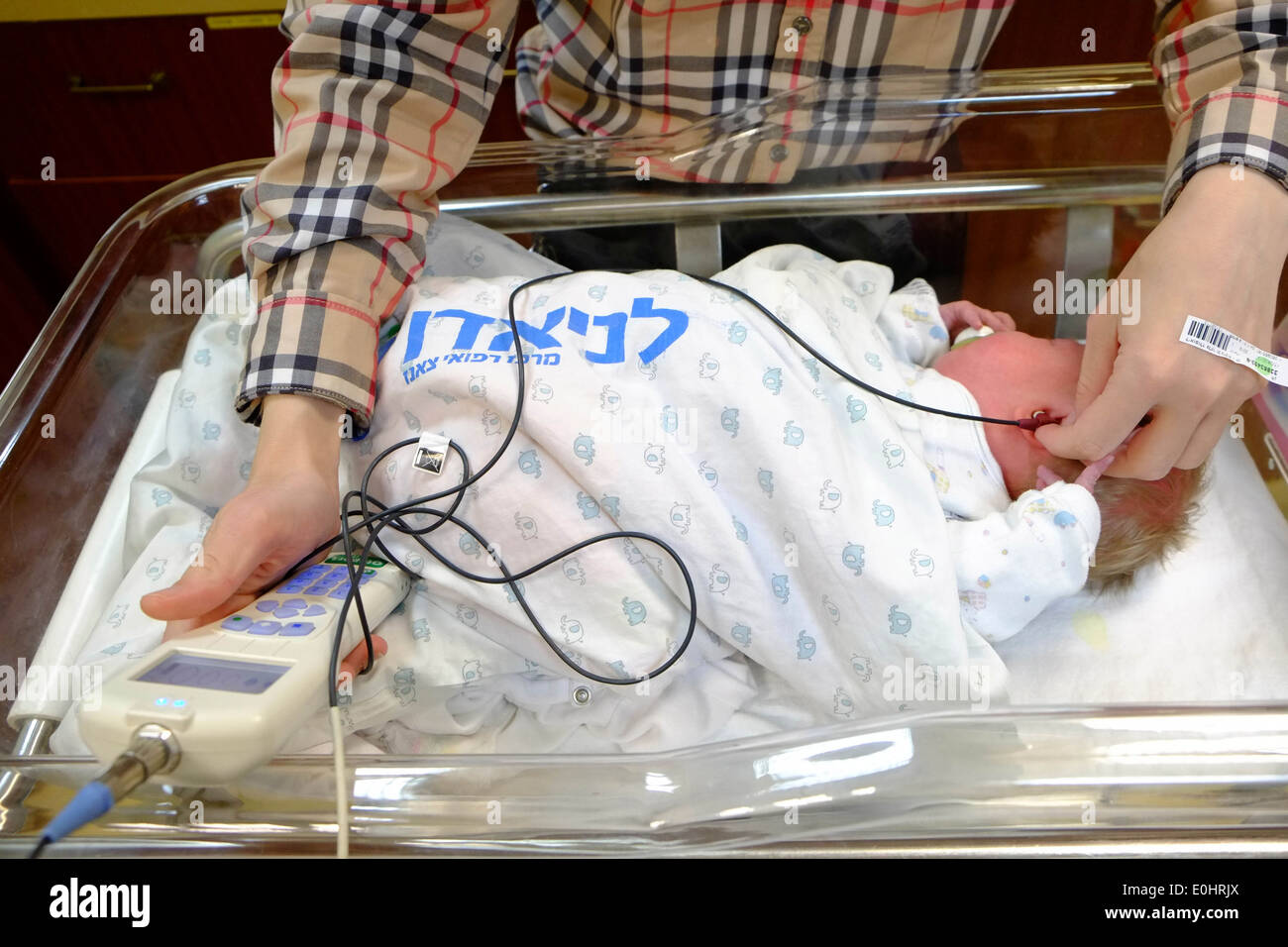 Ein Hörtest wird auf ein neugeborenes Kind in einer Entbindungsstation durchgeführt. Stockfoto