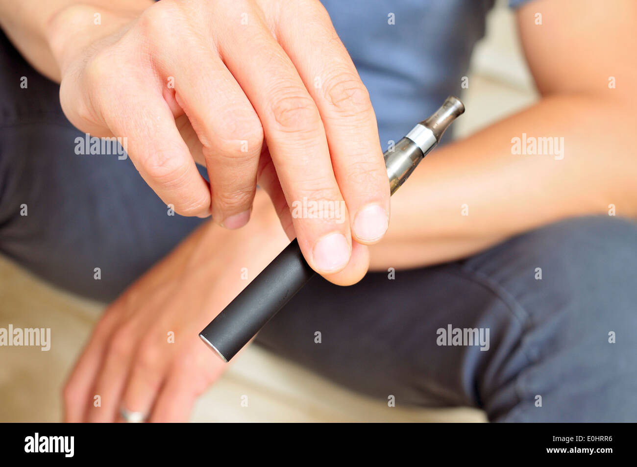 junger Mann Dampfen mit einer elektronischen Zigarette Stockfoto