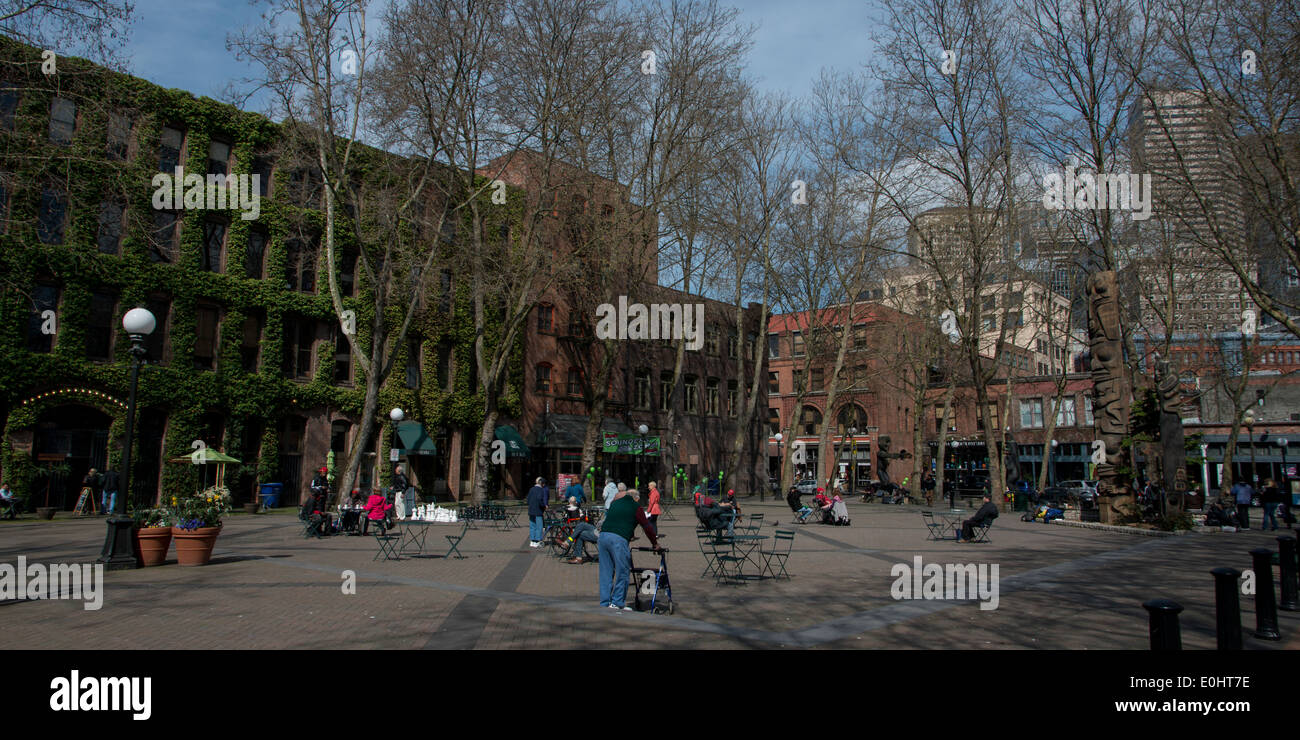 Menschen im Occidental Park mit Gebäuden im Hintergrund, Pioneer Square, Seattle, Washington State, USA Stockfoto
