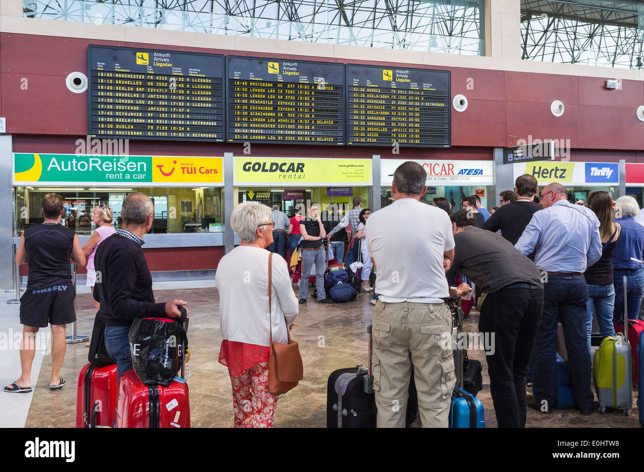 Passagiere, die Warteschlangen an Autovermietung in Teneriffas Reina Sofia Flughafen, Kanarische Inseln, Spanien. Stockfoto