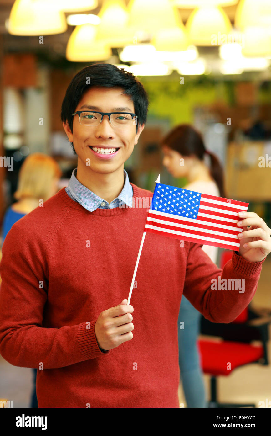 Fröhliche asiatische Studentin, die Flagge der USA Stockfoto