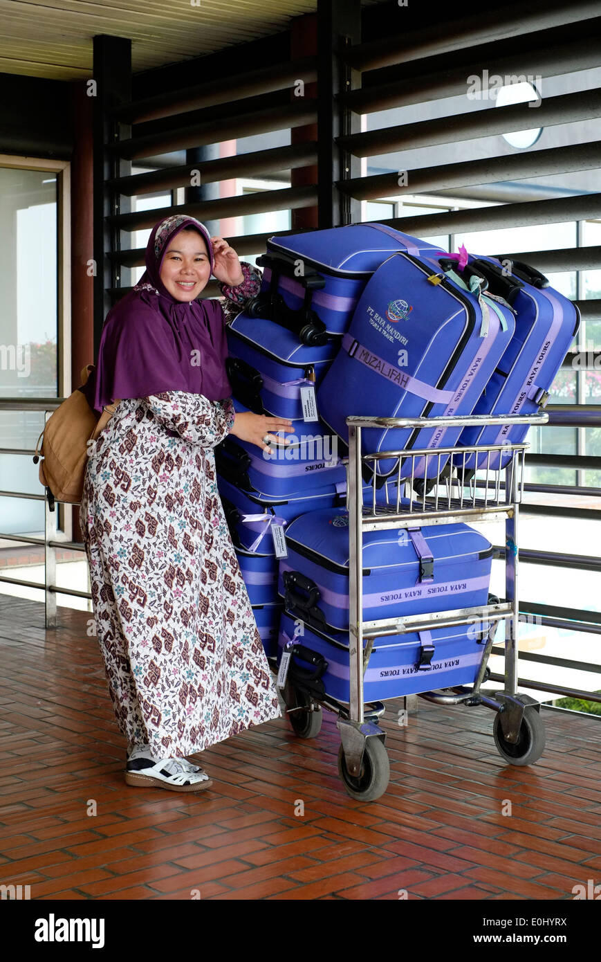 Beifahrerin mit passender Farbe Kleidung und Gepäck am internationalen Flughafen Soekarno-Hatta Jakarta Indonesien Stockfoto