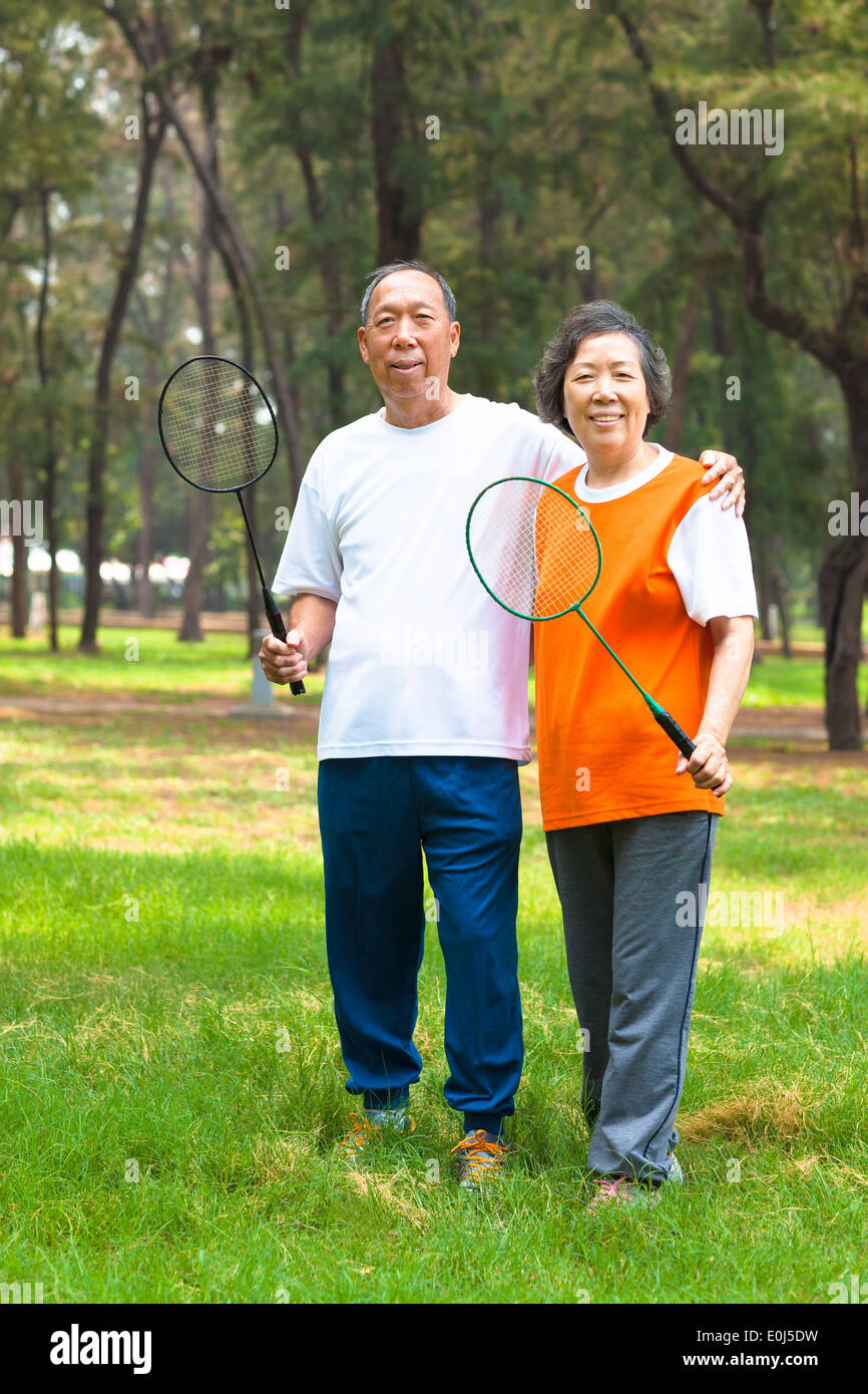 lächelnde ältere Geschwister und Schwester hält Badminton-Schläger Stockfoto