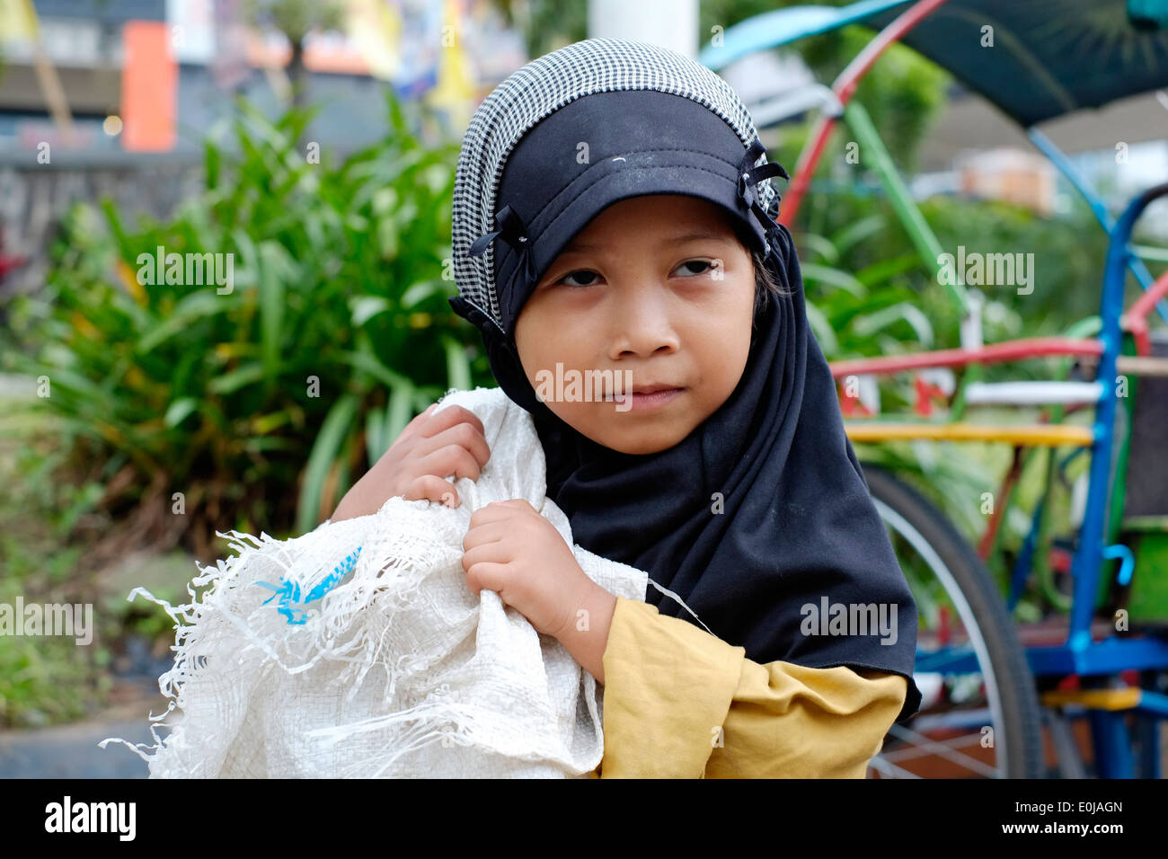 kleine Straße Mädchen tragen riesige meschotschek, Kunststoffabfälle, auf zu verkaufen, für das recycling in Malang Ost Java Indonesien zu sammeln Stockfoto