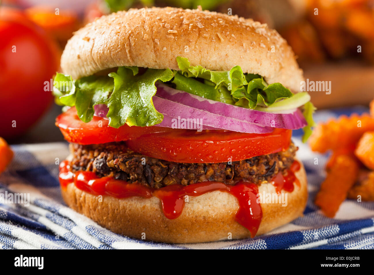 Hausgemachte gesunde vegetarische Quinoa-Burger mit Salat und Tomate Stockfoto