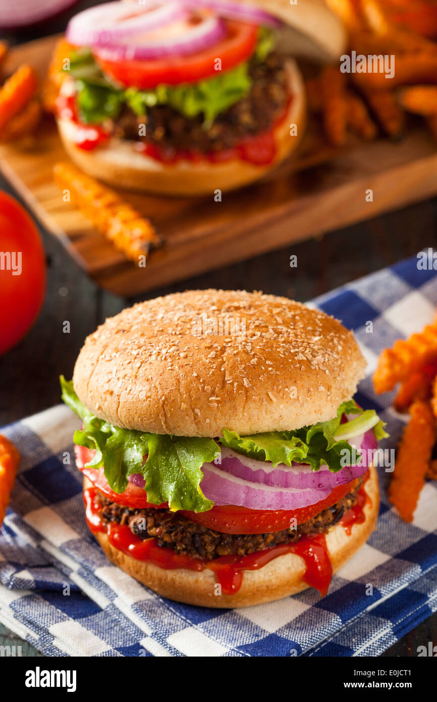 Hausgemachte gesunde vegetarische Quinoa-Burger mit Salat und Tomate Stockfoto