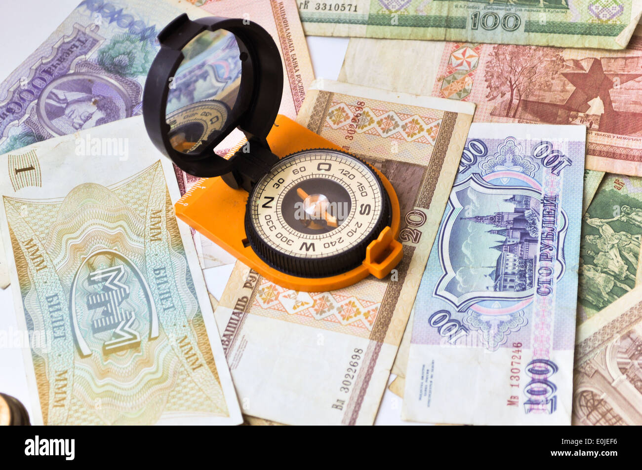 Banknoten und Kompass. Navigation in der Welt der Finanzen. Auf einem weißen Hintergrund sind alte Banknoten, ist ein Kompass. Stockfoto