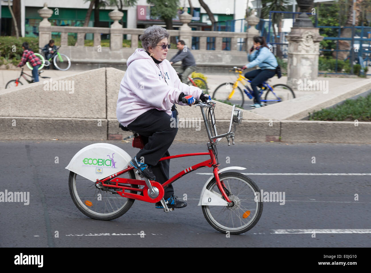 Reife Frau reitet ein Ecobici entlang der Paseo De La Reforma auf autofreien Sonntag Stockfoto