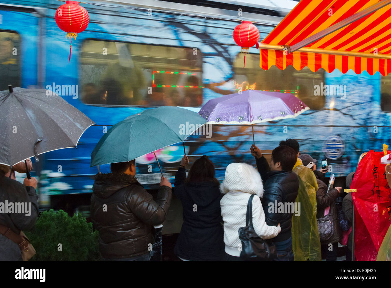 Touristen mit Regenschirm warten trainieren auf der alten Straße in Shifen, Pingxi, Taiwan Stockfoto