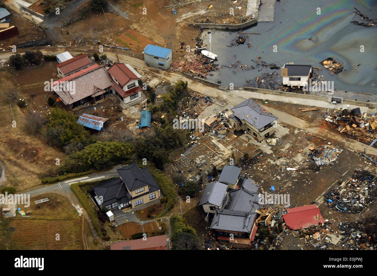 Häuser liegen in Trümmern in dieser Küste von Japan. U-Jagd Hubschrauberstaffel 14 führt humanitären Hilfe ein Stockfoto