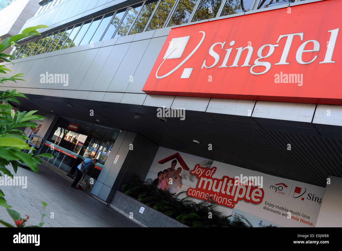 Singapur. 31. März 2014. Ein sauberer arbeitet vor der SingTel Gebäude in Singapur Orchard Road Gegend, am 15. Mai 2014. SingTel sagte am Mittwoch, dass seine Leistung für das Geschäftsjahr endend am 31. März 2014 um 4 Prozent auf 3,65 Milliarden Singapur-Dollar erhöht. © Dahin Chih Wey/Xinhua/Alamy Live-Nachrichten Stockfoto