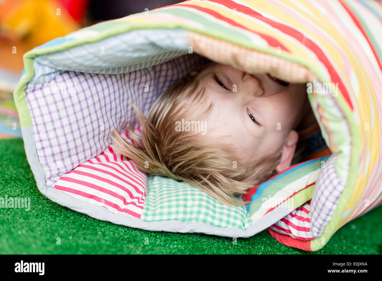 lachender Junge in eine Decke gehüllt, (Model Release) Stockfoto