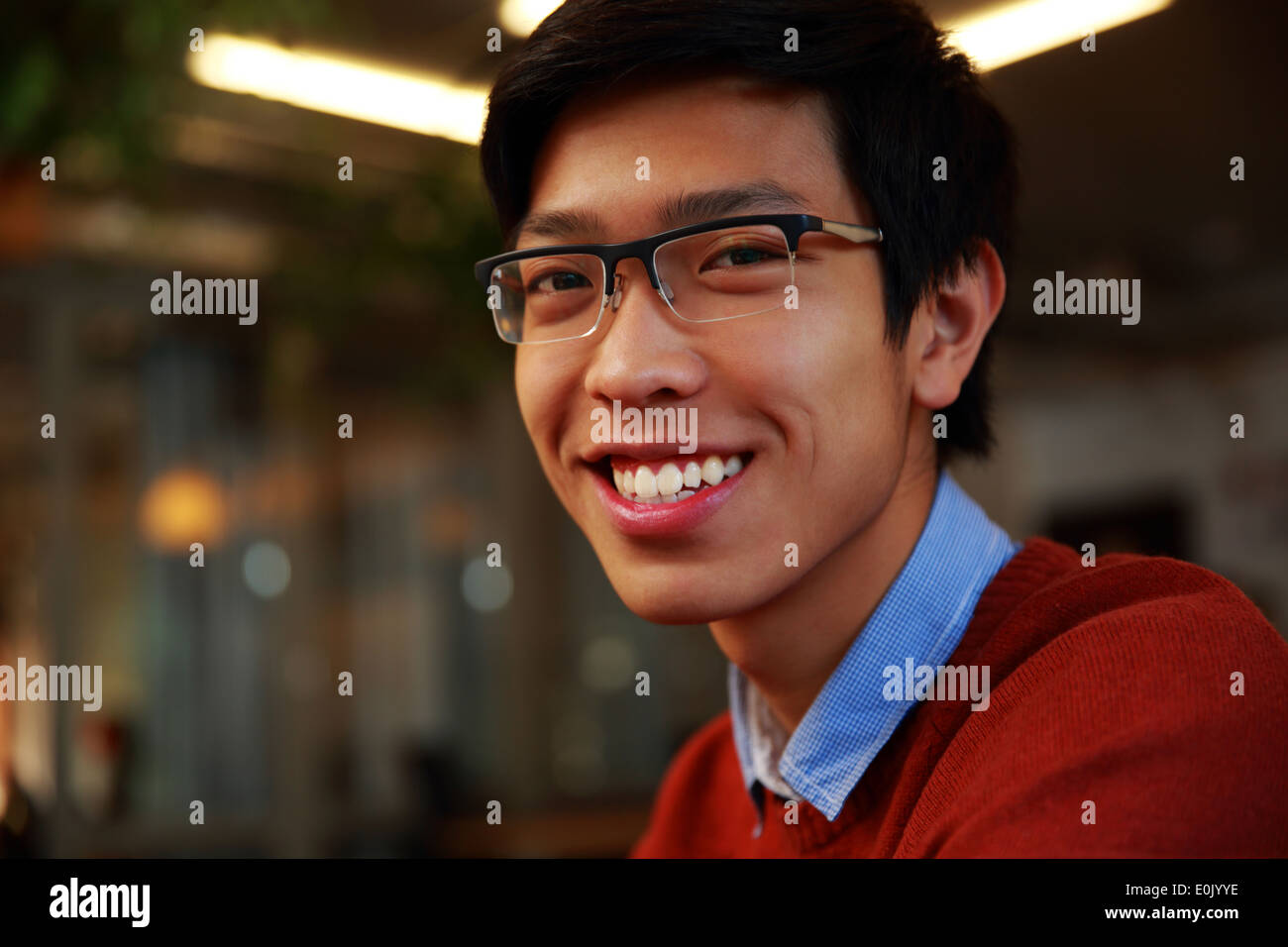 Closeup Portrait eines jungen lächelnd asiatischen Mannes mit Brille Stockfoto