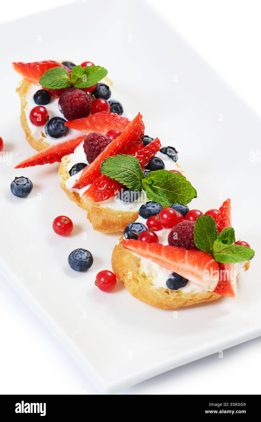 Windbeutel mit Beeren Johannisbeeren Erdbeeren und Heidelbeeren Stockfoto