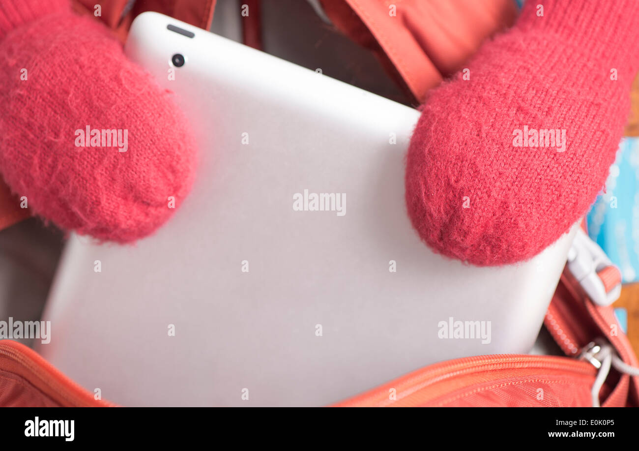 Kind mit roten Winter Handschuhe heben digital Tablet-Computer von Schultasche Stockfoto