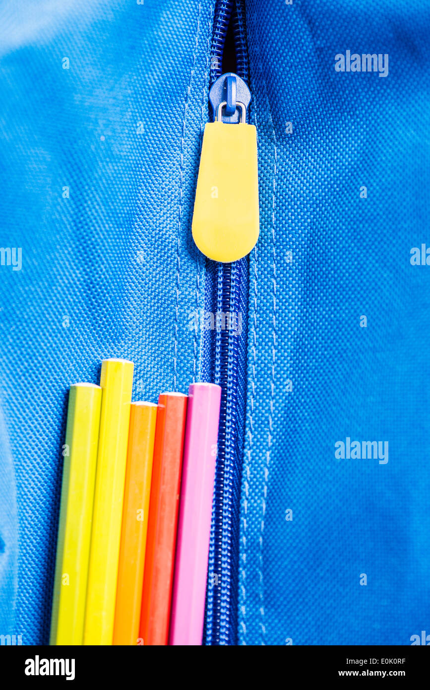 Bunte Stifte auf blaue Schultasche Stockfoto