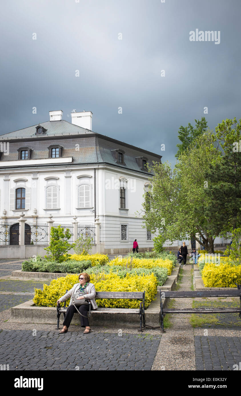 Alte Frau auf einer Bank Hodžovo Namestie, Bratislava, bewölkten Tag Stockfoto