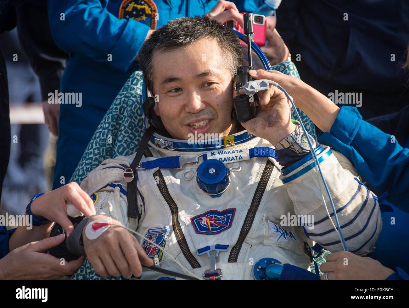 ISS-Expedition 39 Kommandant Koichi Wakata der Japan Aerospace Exploration Agency Gespräche über ein Satellitentelefon in einem Stuhl außerhalb der Sojus-Kapsel, nur wenige Minuten nach der Landung mit anderen Expedition-Crew-Mitglieder in das Raumschiff Sojus TMA - 11M 14. Mai 2014 in der Nähe der Stadt Zhezkazgan, Kasachstan. Wakata, Tyurin und Mastracchio Rückkehr zur Erde nach mehr als sechs Monate an Bord der internationalen Raumstation ISS, wo sie als Mitglieder der Expedition 38 und 39 Mannschaften dienten. Stockfoto