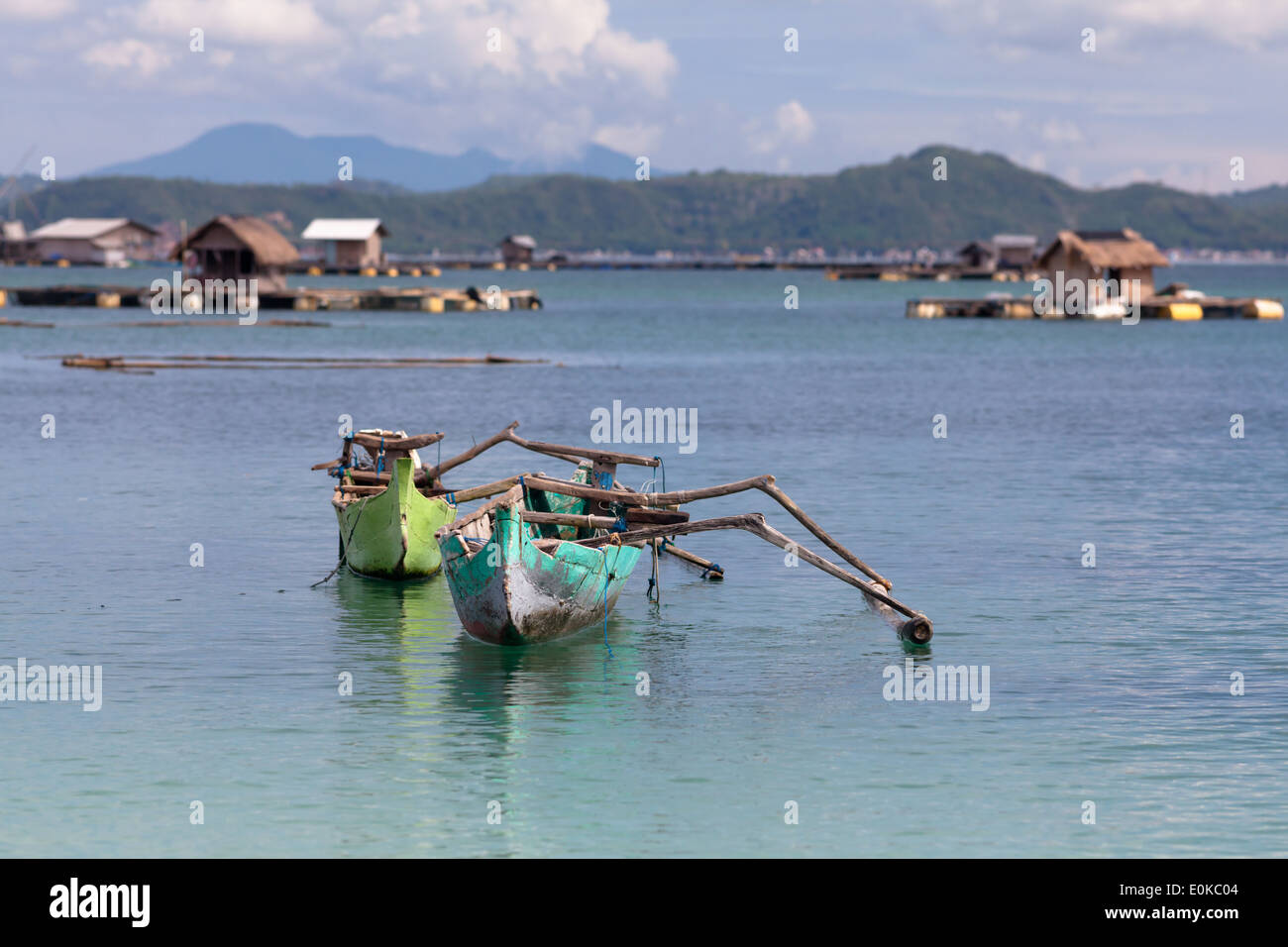 Traditionelle Boote und schwimmenden Hütten (verwendet, um Meeresfrüchte wachsen) – Landschaft der Ekas Bucht, gesehen aus Region der Ekas, Lombok, Indonesien Stockfoto