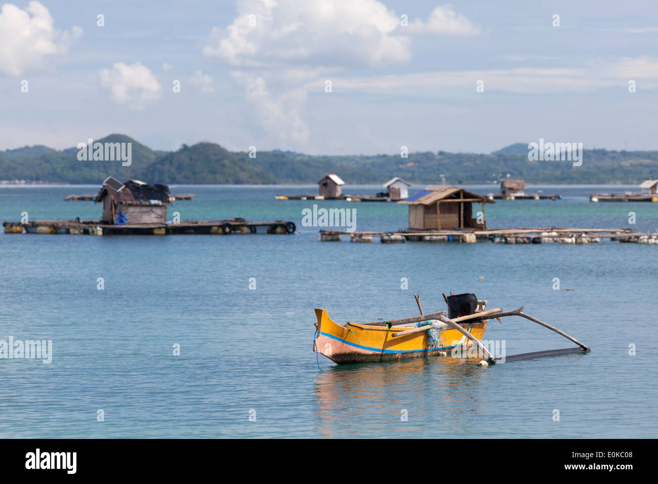 Traditionelles Boot und schwimmenden Hütten (verwendet, um Meeresfrüchte wachsen) – Landschaft der Ekas Bucht, gesehen aus Region der Ekas, Lombok, Indonesien Stockfoto