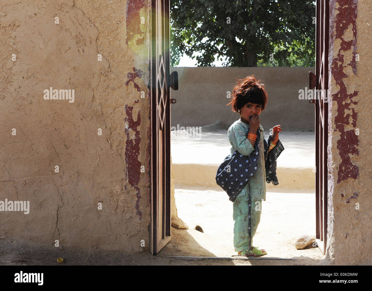 Eine junge afghanische Frau entnimmt eine Tür als eine Patrouille der