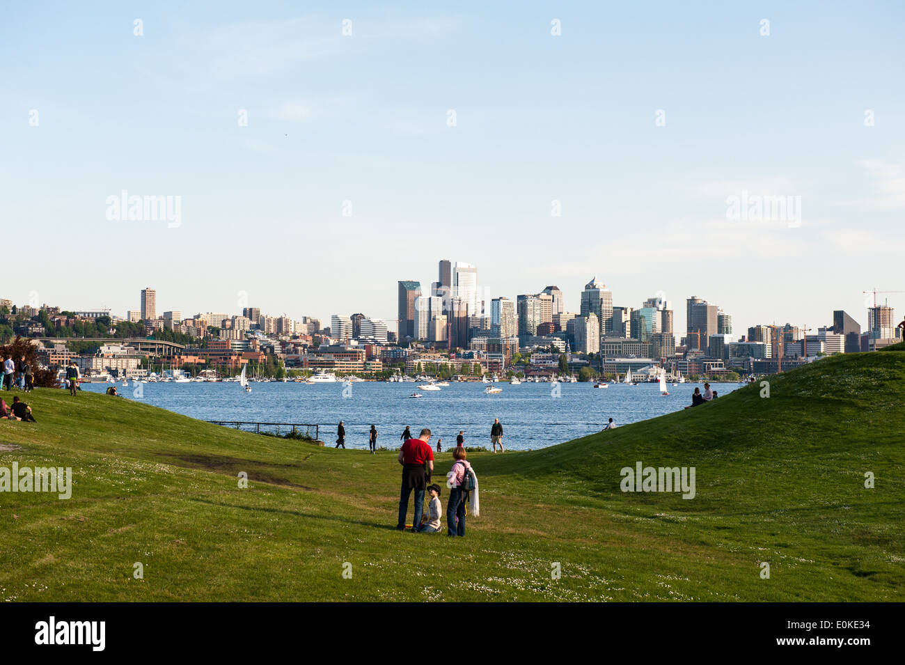 Familien und Freunde versammeln sich am Gas Works Park mit Blick auf Lake Union und die Skyline von Seattle. Stockfoto