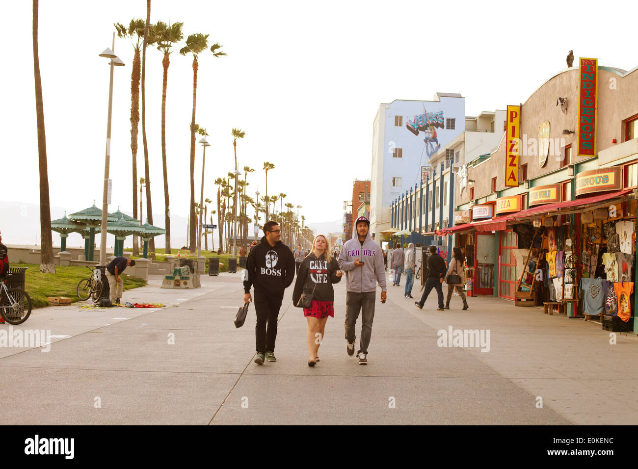 Drei Freunde gehen auf der sonnigen Venice Beach Boardwalk in Los Angeles, Kalifornien. Stockfoto