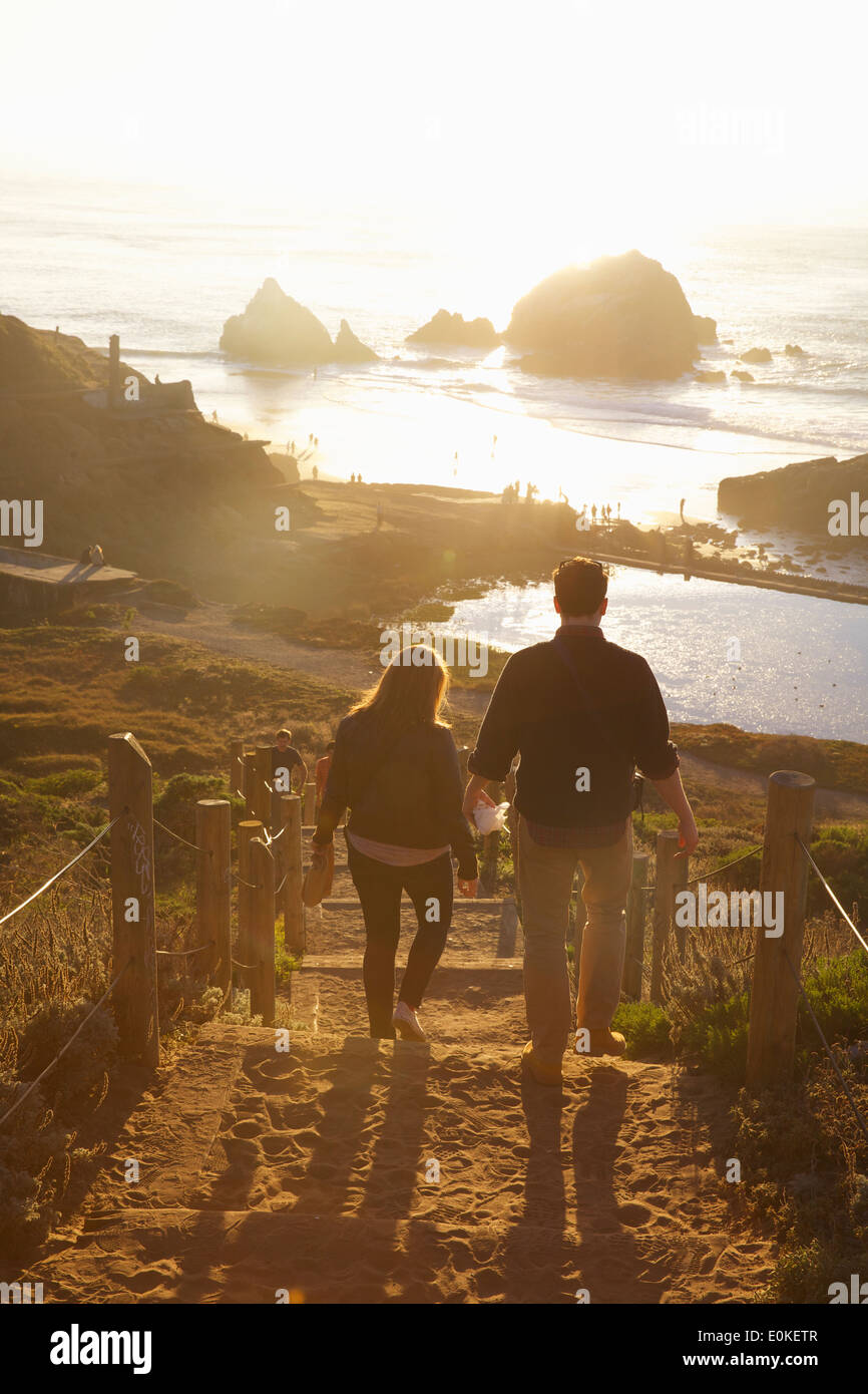 Ein paar steigt die Treppen aus Holz und Sand in der späten Nachmittagssonne auf die Sutro Baths in San Francisco, Kalifornien. Stockfoto