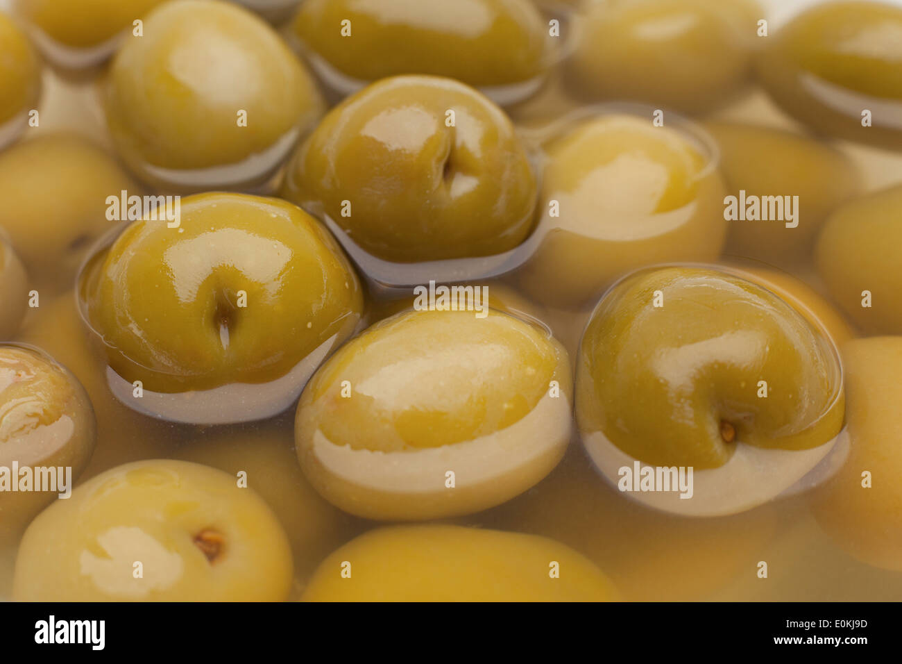 Marinierte grüne Oliven Closeup Hintergrund Stockfoto