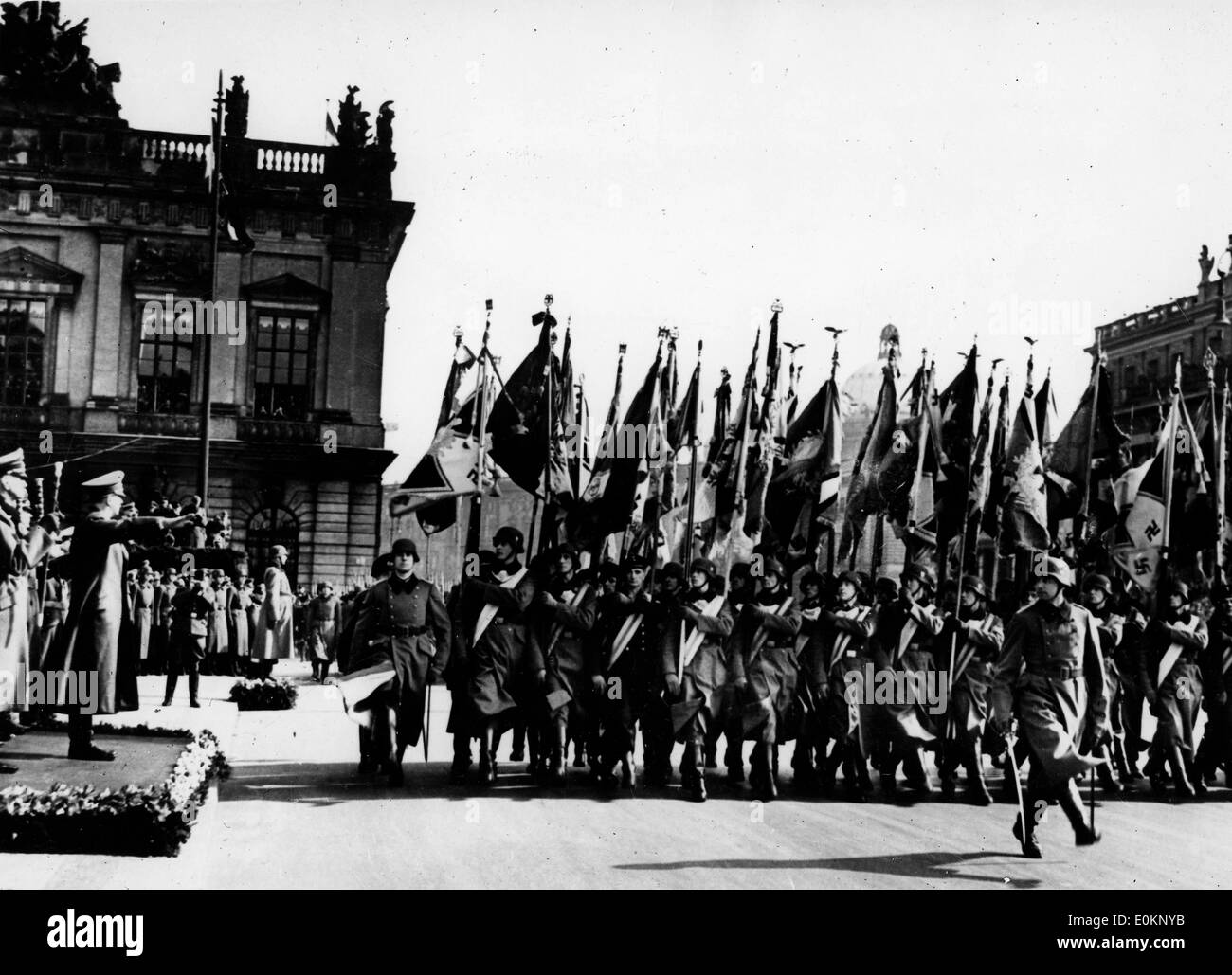 Adolf Hitler nimmt den Salute, während Soldaten ihre Regiments Flaggen halten Stockfoto