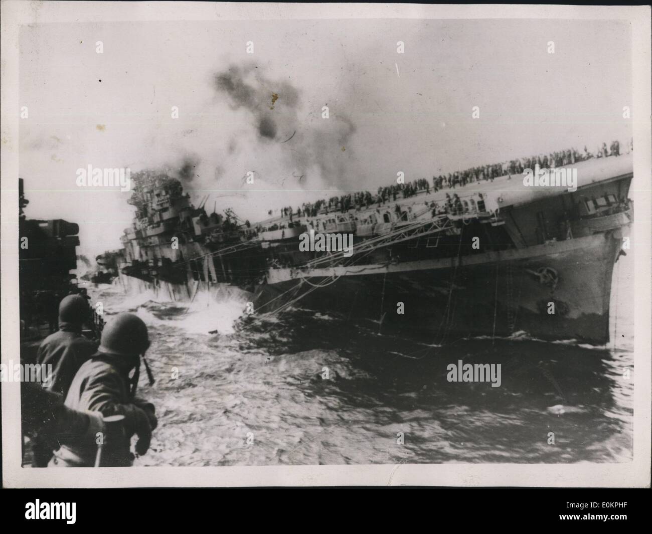 5. Mai 1945 - Träger lebt durch Ordeal of Fire: Foto zeigt The Cruiser Santa FE, Vordergrund, zieht von der dialektgefärbte erleichtert-Klasse-Träger, U.S.S.Franklin, wie die schlecht Inserat Träger, Opfer von einem Jap Sturzbombardierungen Angriff, scheint fast zum Kentern, angetrieben durch Flammen und explodierenden Bomben und Raketen, die tapfere Schiff Besatzung Clustermitglieder nach vorn auf dem Flugdeck , warten auf Einsätze zur Brandbekämpfung Details. Feindliche Flugzeug hatte zwei 500 Pfund Bomben durch die Träger Flight Deck während She japanische Havel Einheiten vor der Jap-Küste getrieben. Stockfoto