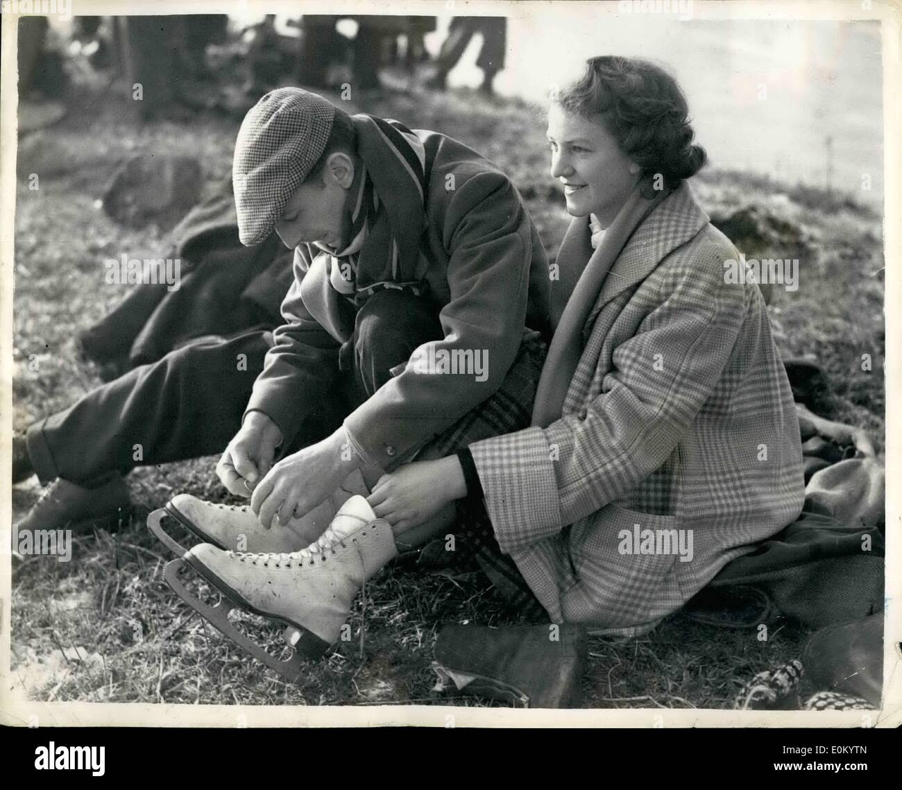 12. Dezember 1952 - Schlittschuhlaufen auf Bury Fen. Brüder und Schwester ein Just ihre Skates.: Foto zeigt Herr A.O. Cole hilft seiner Schwester Norma Stockfoto