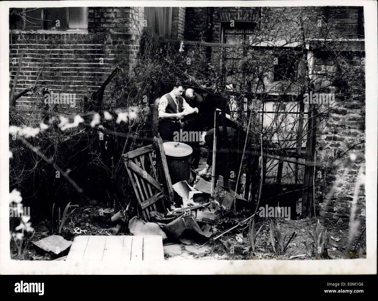 26. März 1953 - Haus des Todes Jagd geht weiter: Polizei nahm heute ihre Untersuchungen am Haus in Rillington Platz, Notting Hill, wo vier Frauen gefunden wurden erdrosselt und in der Erdgeschosswohnung mit Brettern vernagelt. Foto zeigt heute Polizisten suchen Throughh Müll in den Rücken Garten des Hauses am Rillington-Pläne. Stockfoto